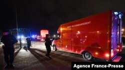 ক্যালে উপকূলে নৌকা ডুবে ২৭ জন অভিবাসী মারা যাবার পর পুলিশ কর্মকর্তারা ক্যালে বন্দরের ফায়ার কমান্ড সেন্টারের পাশে দাঁড়িয়ে আছেন। নভেম্বর ২৪, ২০২১। 