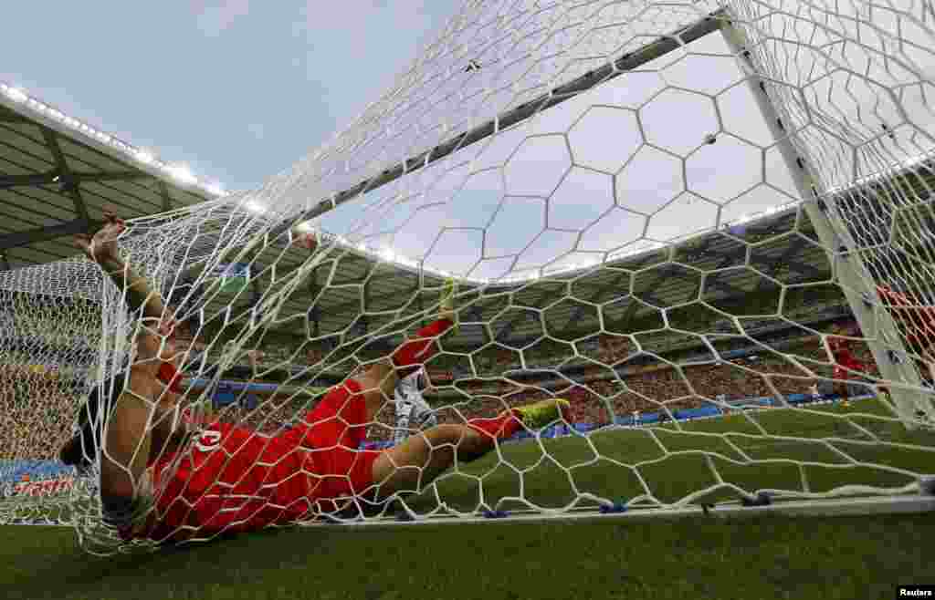 Swiss Ricardo Rodriguez ends up in the net after a save against Honduras at the Amazonia arena, in Manaus, June 25, 2014.