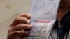 FILE - A foreign national shows a canceled U.S. visa in his passport, having been denied entry, at Washington Dulles International Airport in Chantilly, Virginia, Feb. 6, 2017. 