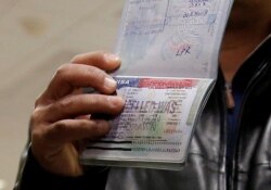 FILE - A foreign national shows a canceled U.S. visa in his passport, having been denied entry, at Washington Dulles International Airport in Chantilly, Virginia, Feb. 6, 2017.
