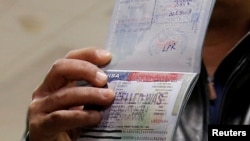 FILE - A foreign national shows a canceled U.S. visa in his passport, having been denied entry, at Washington Dulles International Airport in Chantilly, Virginia, Feb. 6, 2017. 