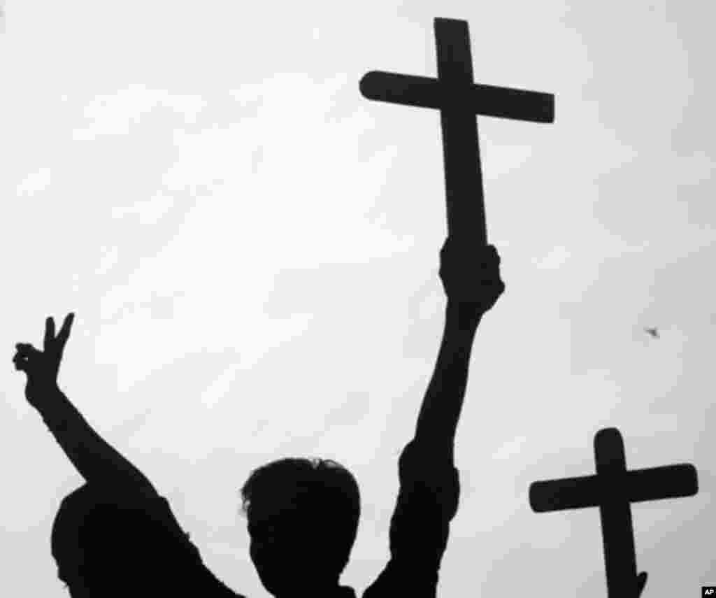 Christians are silhouetted as they hold crosses during a protest in Karachi on March 3, 2011, to condemn the assassination of Shahbaz Bhatti.