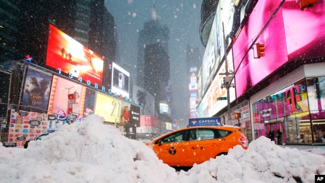 Un taxista pasa entre una montaña de nieve acumulada en Time Square, en la ciudad de Nueva York, el martes, 14 de marzo, de 2017.