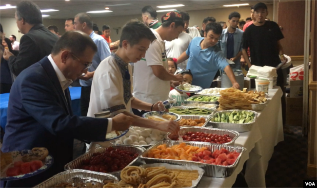 Uighurs eat breakfast together following an Eid prayer at an event in Falls Church, Virginia, Aug. 21, 2018. (B. Gallo/VOA)