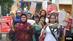 Para perempuan melakukan long march dalam aksi 'Cuci Bersih Korupsi', sambil membunyikan panci-panci menuju nDalem Jayadipuran di Yogyakarta, Minggu sore, 8/3 (foto: VOA/Munarsih).