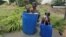 Children sit in plastic containers filled with water as they cool themselves next to a borewell at a farm on a hot summer day on the outskirts of Ahmedabad, India, May 28, 2015.