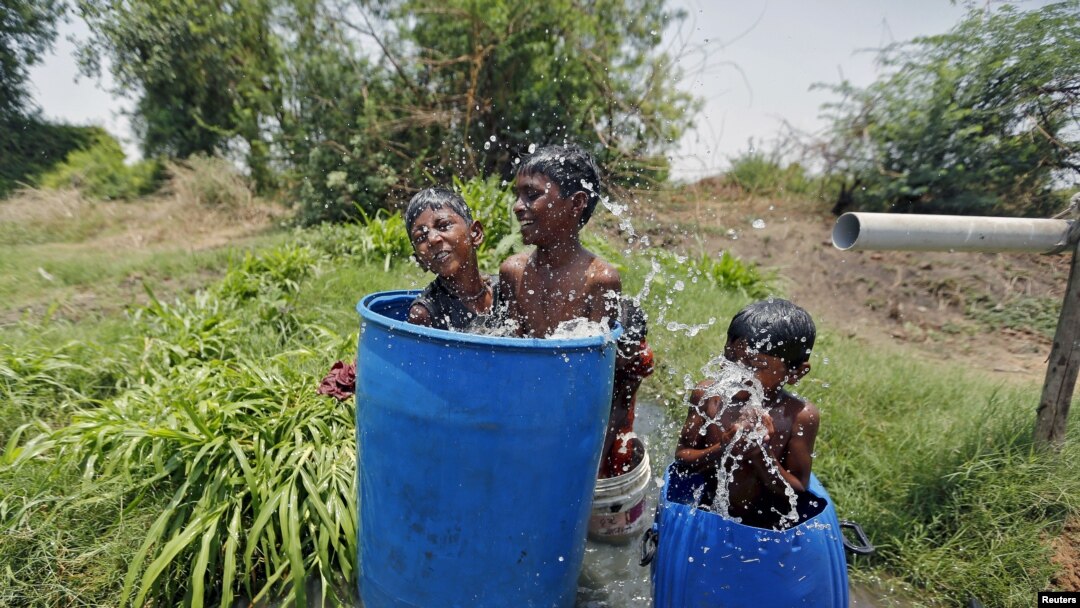 Enfriandose con agua en las afueras de Ahmedabad, India, donde cientos han muerto de calor.