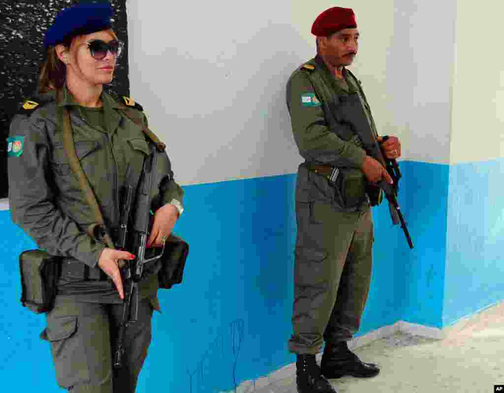 Tunisian soldiers stand guard at a polling station in Marsa, outside Tunis, Nov. 23, 2014.