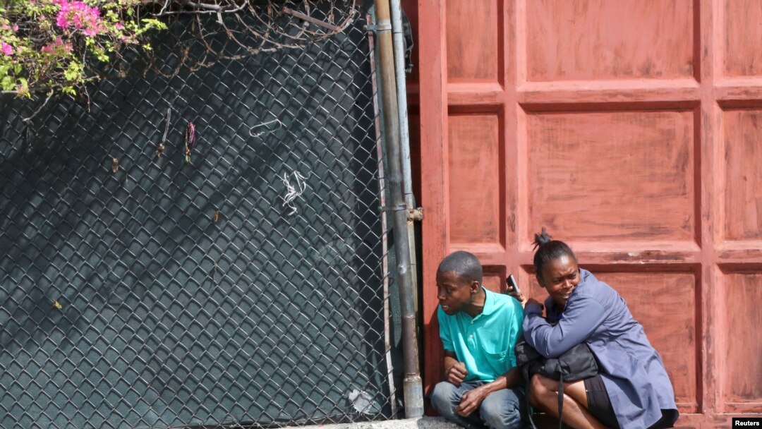 People take cover during clashes between gangs and security forces, in Port-au-Prince