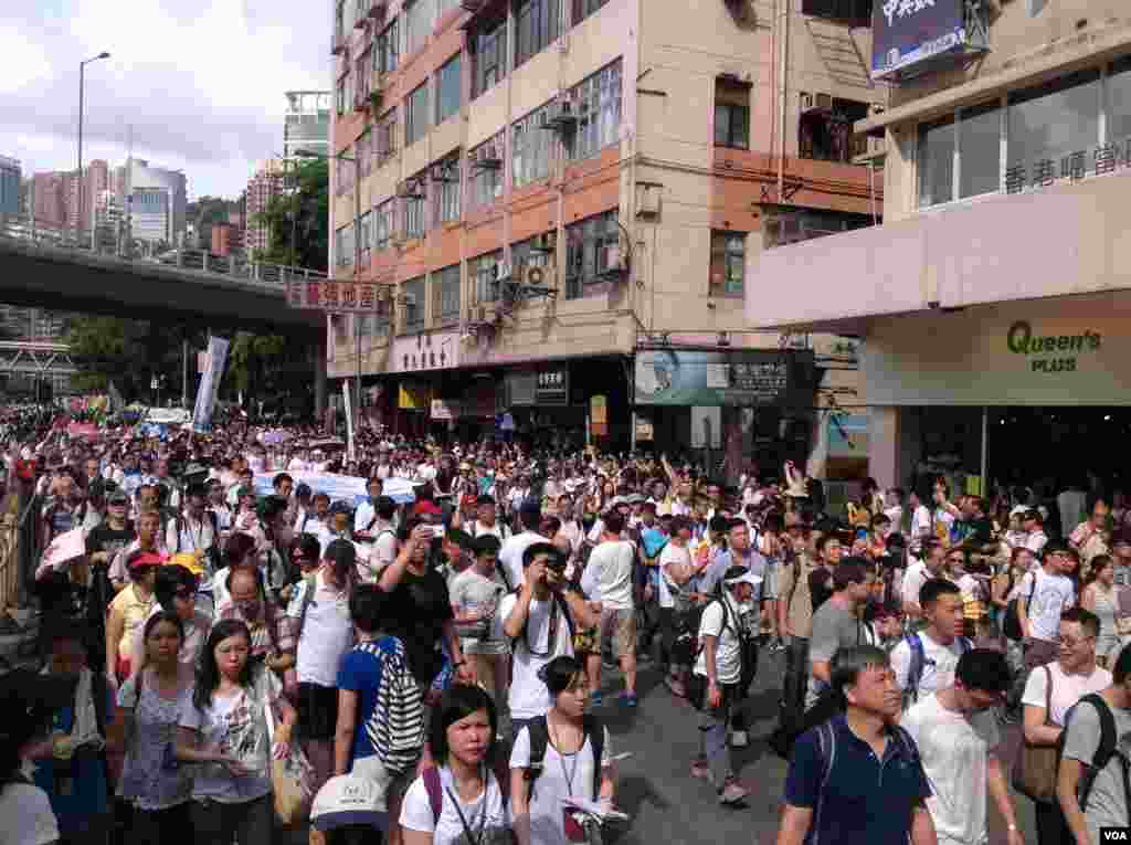 今天是香港回归17周年纪念日，在官方和亲北京团体举行各种庆祝活动的同时，几十万市民下午冒着高温走上街头，参加七一大游行(美国之音海彦拍摄)