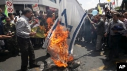 Iranian demonstrators burn a representation of the Israeli flag during their annual protest to mark Quds, or Jerusalem Day, in Tehran, May 31, 2019. 