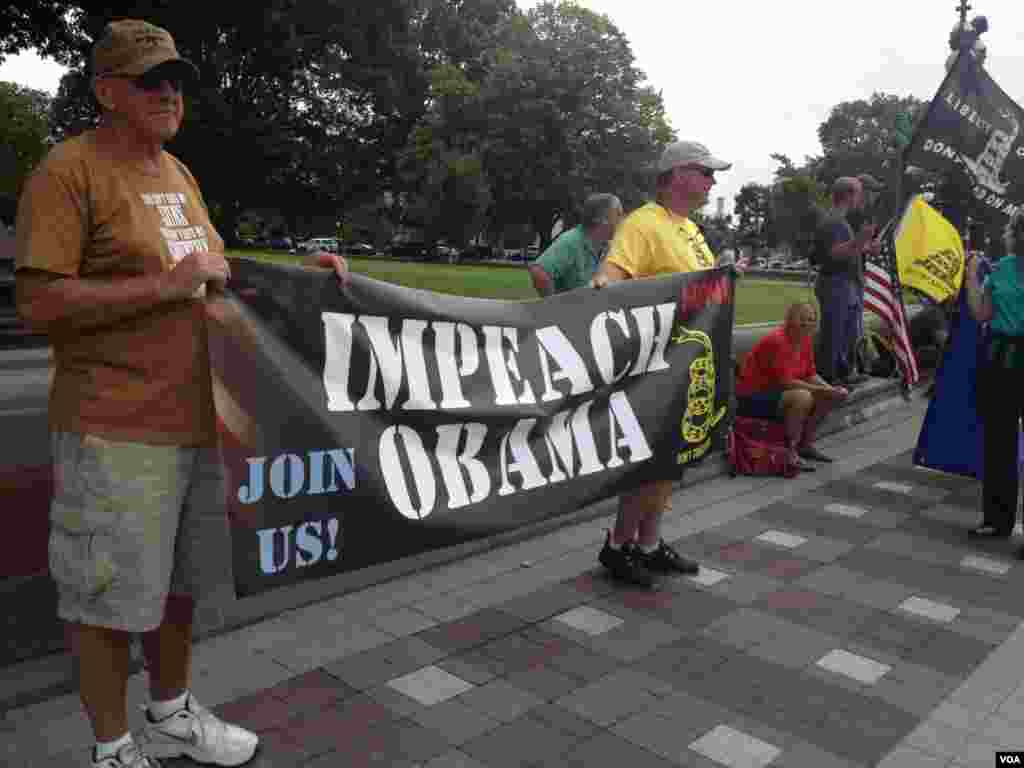 反对美国军事干预叙利亚的抗议人士展示弹劾奥巴马总统的标语。