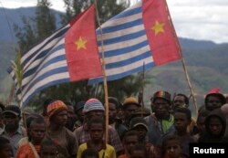 Pendukung Gerakan Papua Merdeka mengibarkan bendera Bintang Kejora saat upacara pengibaran bendera di Kabupaten Paniai Timur, Papua, 17 Oktober 2008. (Foto: REUTERS/Muhammad Yamin)