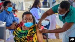 FILE - A woman receives a coronavirus vaccination at the Kololo airstrip in Kampala, Uganda, May 31, 2021. 