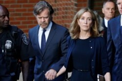 FILE - Actress Felicity Huffman leaves the federal courthouse with her husband, William H. Macy, after being sentenced in connection with a nationwide college admissions cheating scheme in Boston, Sept. 13, 2019.