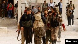 FILE - Free Syrian Army fighters carry the body of a fellow fighter who was killed during what FSA rebels say were clashes with forces loyal to President Bashar al-Assad near Aleppo International airport.