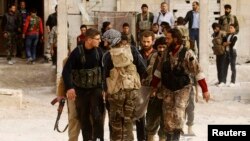 FILE - Free Syrian Army fighters carry the body of a fellow fighter who was killed during what FSA rebels say were clashes with forces loyal to President Bashar al-Assad near Aleppo International airport.