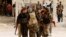 FILE - Free Syrian Army fighters carry the body of a fellow fighter who was killed during what FSA rebels say were clashes with forces loyal to President Bashar al-Assad near Aleppo International airport.