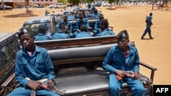 FILE - Police officers sit on the back of pickup trucks as they prepare to patrol the streets of Juba, South Sudan, April 9, 2020. A new U.N. report accuses the country's government and security forces of gross violations.