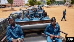 FILE - Police officers sit on the back of pickup trucks as the prepare to patrol the streets of Juba, South Sudan, April 9, 2020. 