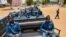 FILE - Police officers sit on the back of pickup trucks as the prepare to patrol the streets of Juba, South Sudan, April 9, 2020. 