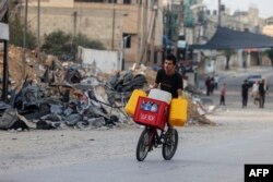 FILE - A young man transports jerricans of water on a bicycle in Rafah in the southern Gaza Strip October 22, 2023, amid ongoing battles between Israel and the Palestinian Hamas movement.