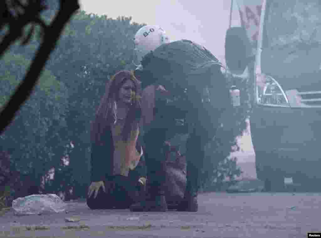 A police officer helps a woman during an anti-government protest in Istanbul, Turkey, June 3, 2013. 