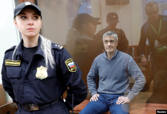 Founder of the Baring Vostok private equity group Michael Calvey, who was detained on suspicion of fraud, sits inside a defendants' cage as he attends a court hearing in Moscow, Feb. 15, 2019.