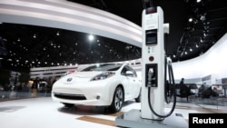 FILE: A Nissan Leaf electric car is displayed next to a charging stand at the North American International Auto Show in Detroit, Jan.12, 2016. The Leaf is one of many Nissans that will come with automatic braking standard in the 2018 model year. 