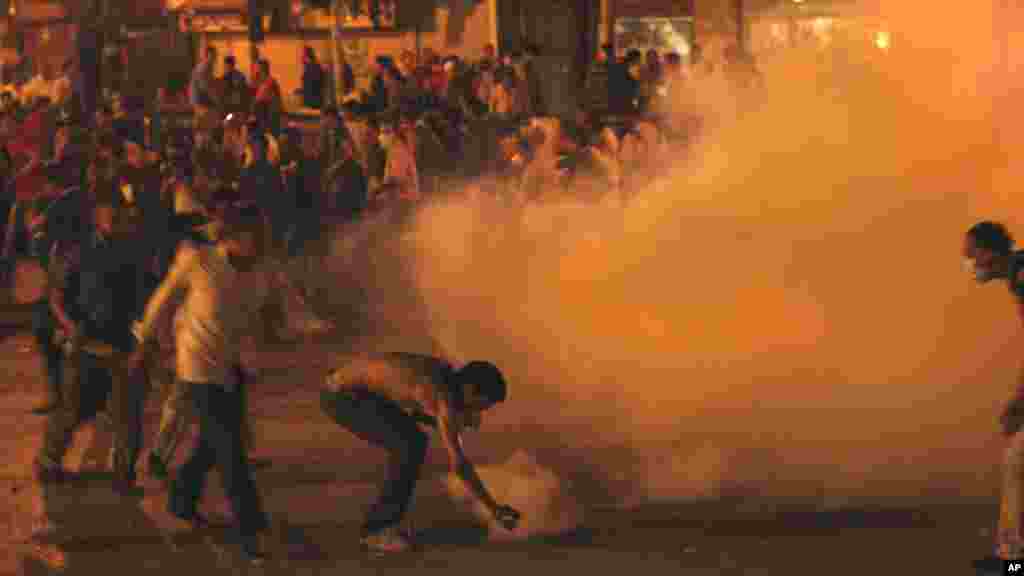 Des manifestants lancent une grenade de gaz lacrymogène lors d&#39;affrontements avec la sécurité égyptienne sur la place Tahrir au Caire, en Egypte, 29 juin 2011.