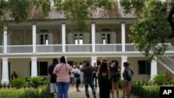 FILE - Visitors walk outside the main plantation house at the Whitney Plantation in Edgard, La., July 14, 2017.