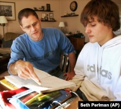 FILE - Illinois Rep. Jim Watson helps his son Jacob with his homework in Jacksonville, Ill., Tuesday, Jan. 15, 2008.