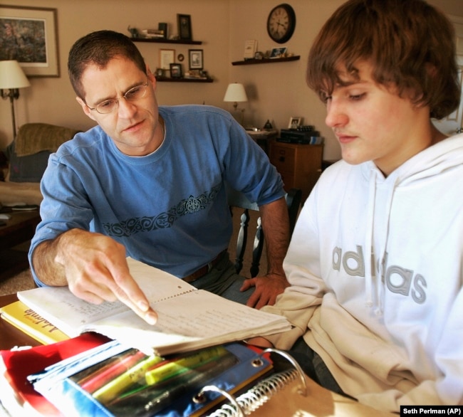 FILE - Illinois Rep. Jim Watson helps his son Jacob with his homework in Jacksonville, Ill., Tuesday, Jan. 15, 2008.