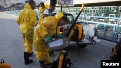 FILE - A municipal worker prepares insecticide to be sprayed at Sambodrome in Rio de Janeiro, Brazil, Jan. 26, 2016. The Sambadrome will be the site of the archery competition during the Rio Olympics.