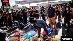 Un grupo de ciudadanos se congrega en un memorial improvisado en honor de George Floyd en el lugar en el que falleció a manos de la policía el pasado 25 de mayo.