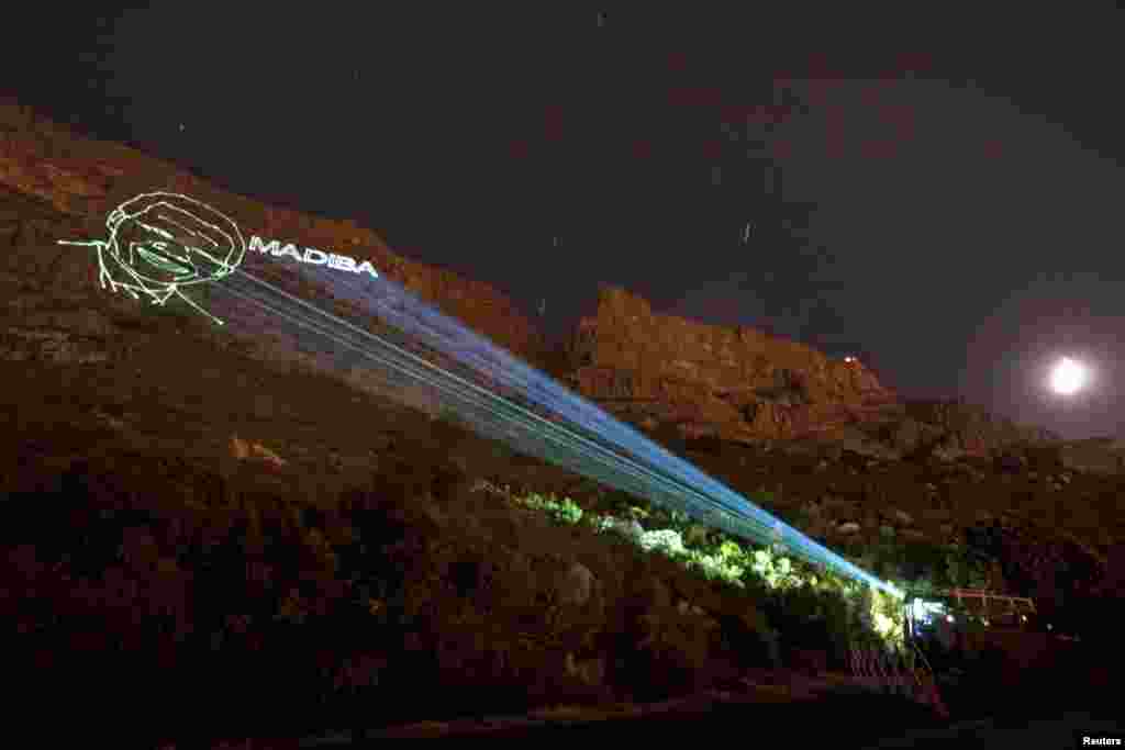 The face of Nelson Mandela and his clan name Madiba is projected onto the face of Table Mountain in Cape Town, South Africa Dec. 8, 2013. 