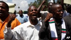 FILE - A handful of anti-corruption demonstrators hold a chain during a protest in downtown Nairobi, Kenya, Feb 17, 2010. An anti-corruption group is expected to soon present a report to President Uhuru Kenyatta, following concerns of endemic graft in public institutions, according to presidential spokesman.