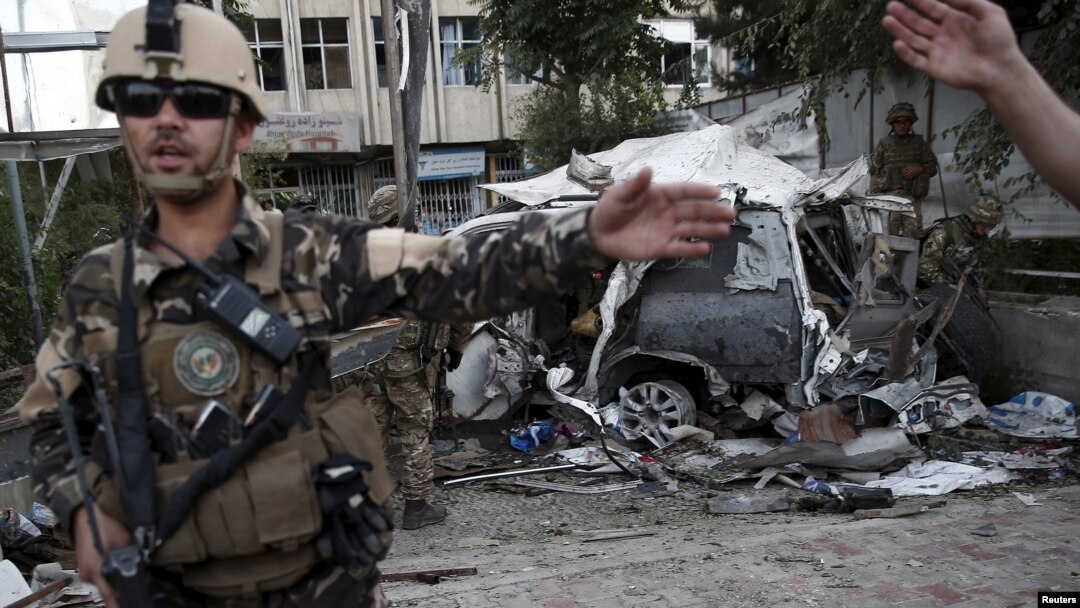 Para anggota pasukan Afghanistan berjaga-jaga di lokasi ledakan bom mobil di Kabul, Afghanistan (22/8). (Reuters/Ahmad Masood)