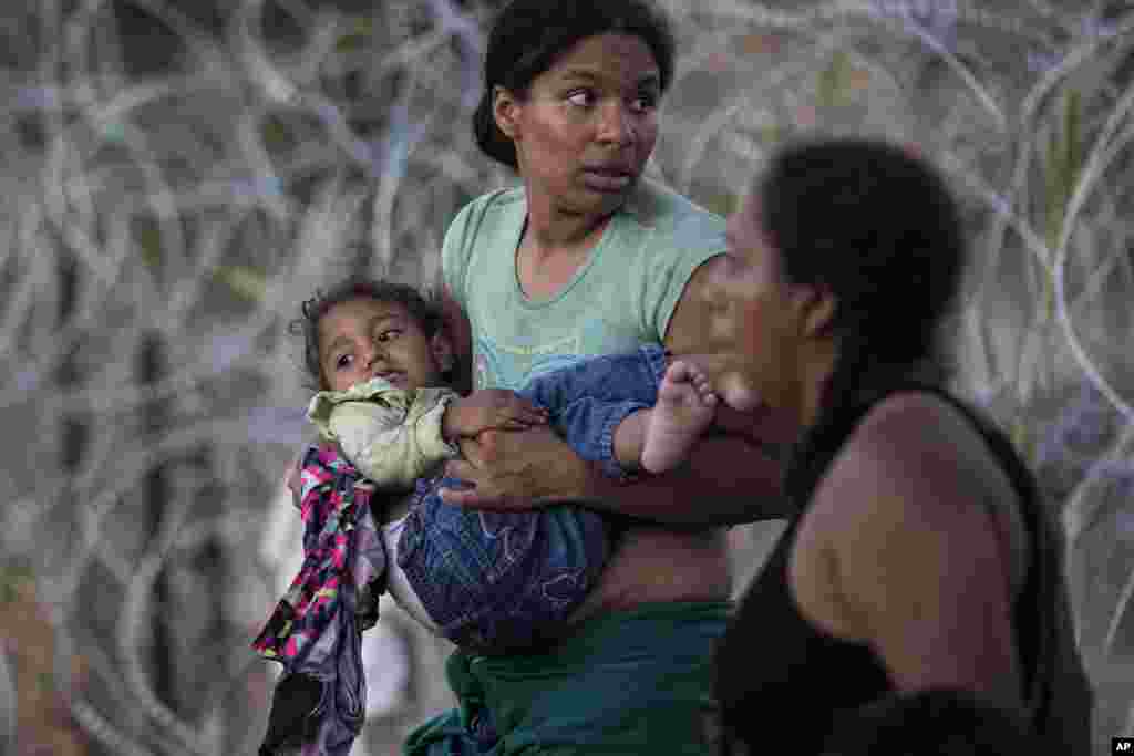 Una mujer con un menor en brazos cruzó junto a otros inmigrantes desde Ro Grande, en México, a Eagle Pass, Estados Unidos, el 23 de septiembre de 2023. [Foto: Eric Gay]