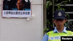 A portrait of the jailed Wukan village chief Lin Zuluan is displayed by protesters demanding the release of Lin outside China Liaison Office in Hong Kong, China, Sept. 14, 2016. 