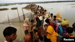 Rohingya refugees wait for boat to cross a canal after crossing the border through the Naf River in Teknaf, Bangladesh, Sept. 7, 2017.