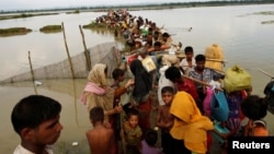 Rohingya refugees wait for boat to cross a canal after crossing the border through the Naf river in Teknaf, Bangladesh, Sept. 7, 2017.