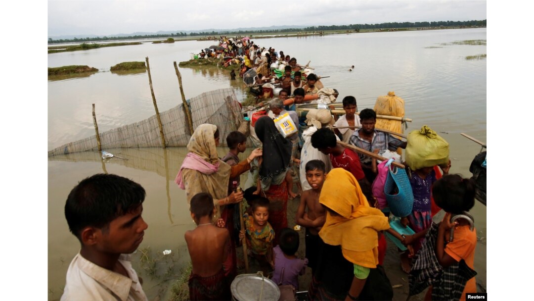 Rohingya refugees wait for boat to cross a canal after crossing the border through the Naf river in Teknaf, Bangladesh, Sept. 7, 2017.