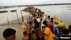 Rohingya refugees wait for boat to cross a canal after crossing the border through the Naf river in Teknaf, Bangladesh, Sept. 7, 2017.