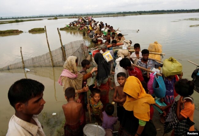 Rohingya refugees wait for boat to cross a canal after crossing the border through the Naf river in Teknaf, Bangladesh, Sept. 7, 2017.