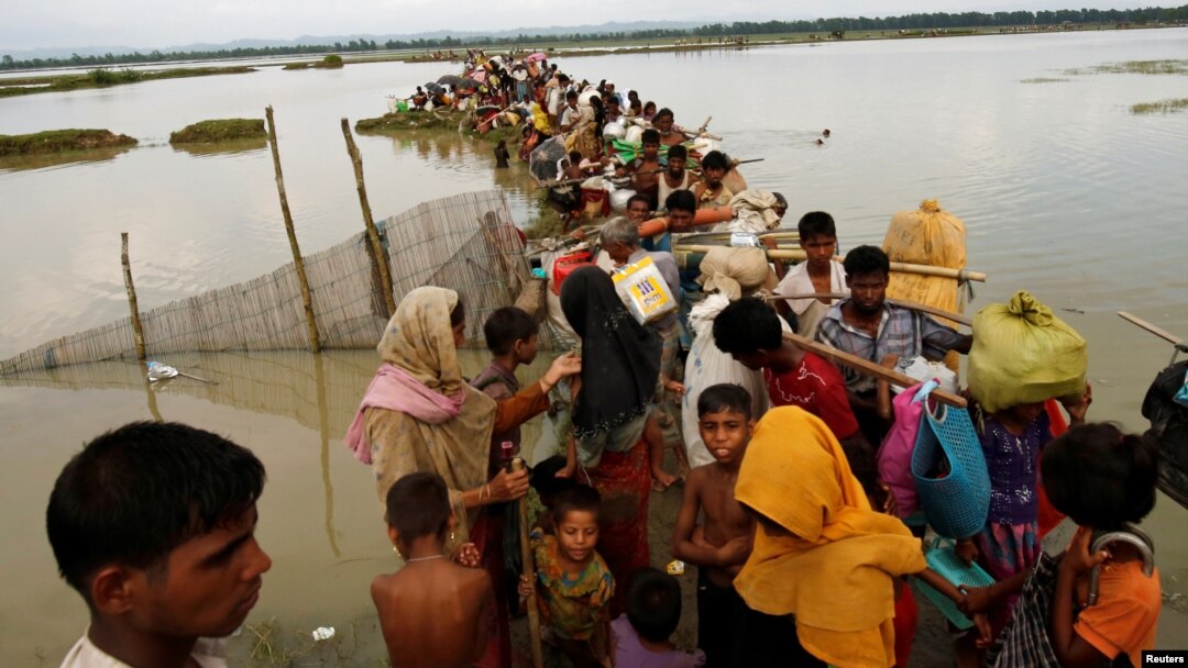 Rohingya refugees wait for boat to cross a canal after crossing the border through the Naf River in Teknaf, Bangladesh, Sept. 7, 2017.