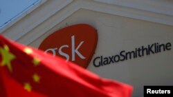 FILE - A Chinese national flag is seen in front of a GlaxoSmithKline office building in Shanghai.