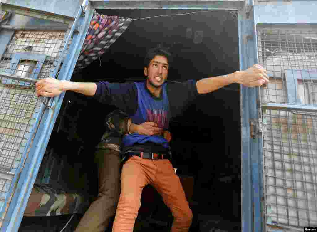 A supporter of Kashmiri lawmaker Sheikh Abdul Rashid, also known as Engineer Rashid, attempts to jump from a police vehicle after he was detained by Indian police during a protest in Srinagar, India. Dozens of supporters of Rashid were detained by police during a protest against the arrest of former Delhi University lecturer (SAR) Syed Abdul Rehman Geelani and also against the deaths of two youths in south Kashmir&#39;s Pulwama district, protesters said.