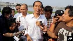 Indonesian presidential candidate Joko Widodo talks to the media during his visit at a reservoir development project in Jakarta, Indonesia, July 22, 2014.