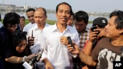 Indonesian presidential candidate Joko Widodo talks to the media during his visit at a reservoir development project in Jakarta, Indonesia, July 22, 2014.